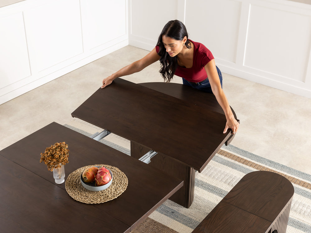 transformer-round-table-dark-walnut-top-angle-shot-lifestyle-models-silver-rail_dc796972-e8a0-44c7-bc89-afc5a109d467